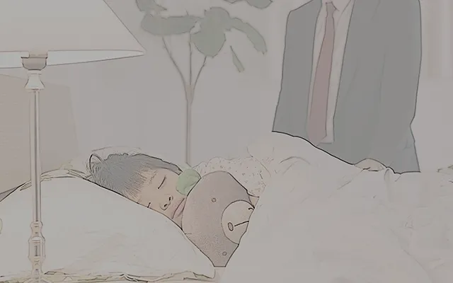 寝ている子供を見ている男性